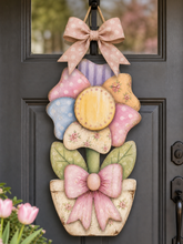 Load image into Gallery viewer, Decorative door hanger with colorful flowers and bows on a black door.
